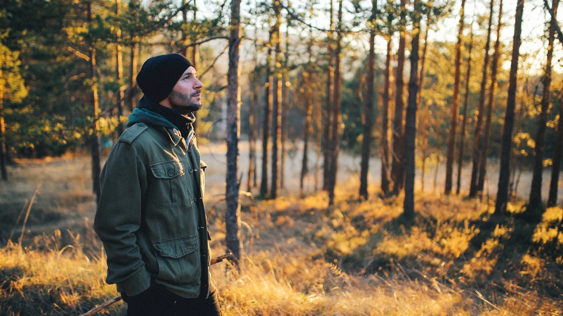 Junger Mann geht durch einen Wald