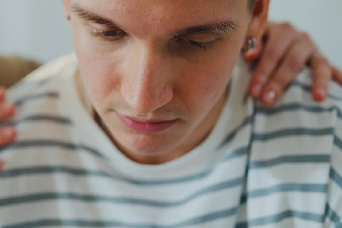 Teenager wird von einem Menschen getröstet